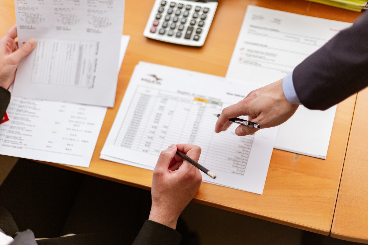 Stock photo depicting two business people consulting papers